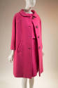 Pink ensemble of blouse, knee-length skirt, and matching coat with four large rhinestone button…