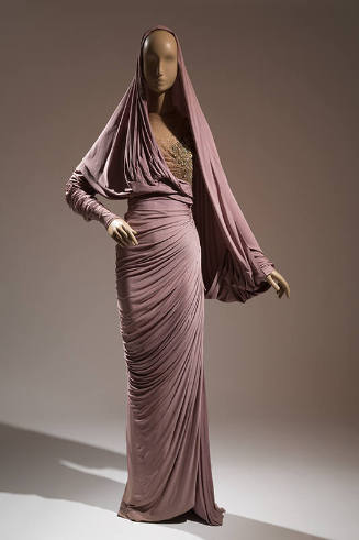 Light purple floor length evening sheath dress, left sleeve panel makes capelet covering the he…