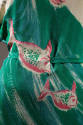 Detail view of two-piece dress showing print with pink fish swimming in blue and green waves
