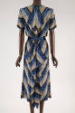 Back view of white, black and blue printed dress showing handkerchief gathering of fabric on ce…