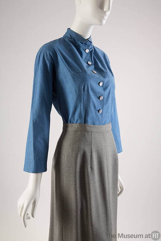 Long sleeve blue denim blouse with 6 pearl buttons paired with grey skirt