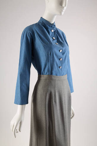 Long sleeve blue denim blouse with 6 pearl buttons paired with grey skirt