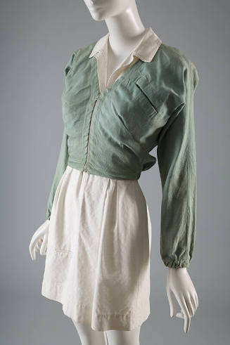 Cropped pale denim V-neck, zippered jacket with cinched sleeves at wrist styled over a  white m…