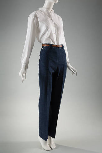 Blue denim jeans, creased at center leg, dressed with white buttoned shirt and brown belt