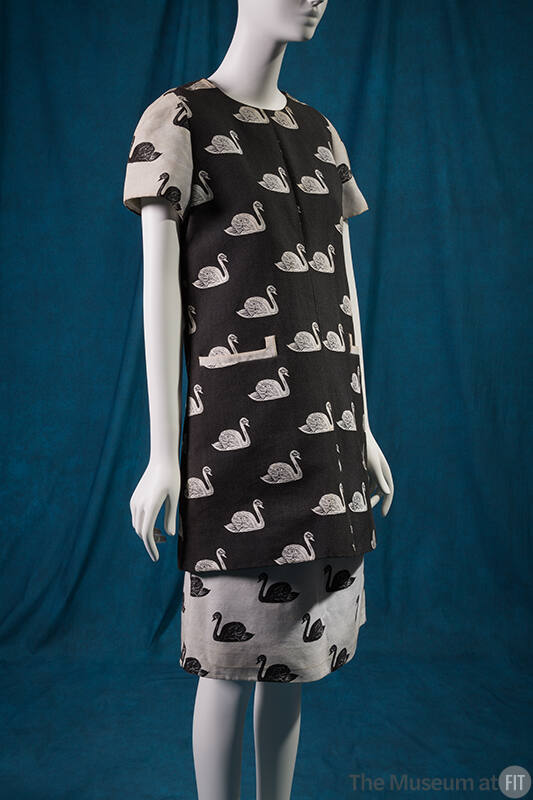 Black tunic with jacquard pattern of white swans and contrasting white short sleeves and knee l…