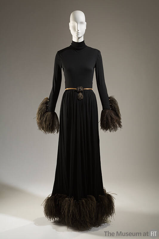 Black floor length evening dress with turtleneck, black ostrich feather trim at wrists and hem …
