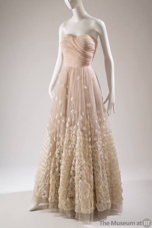 Strapless floor length pale pink ballgown, white feathers stitched on full circle skirt to crea…