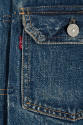 Detail of blue denim patch pocket with metal flap button and red Levi's tag