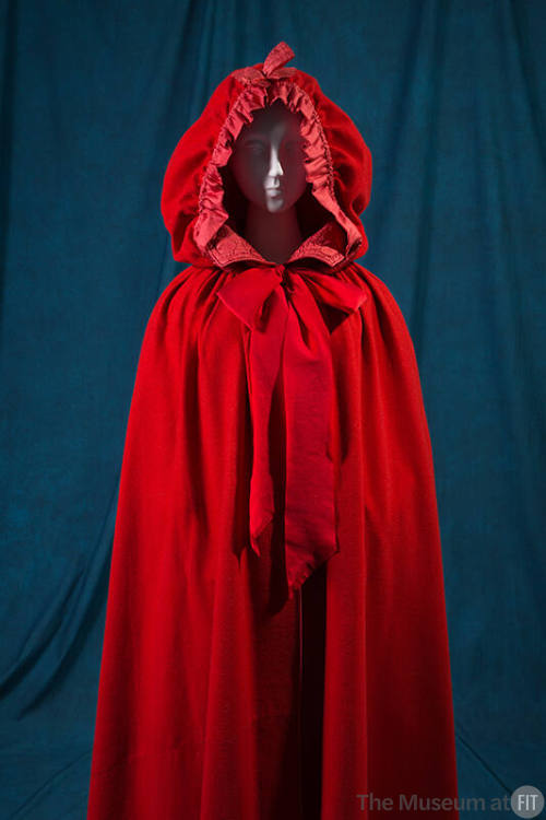 Bright red long cape with attached hood and buttoned front vest with bow