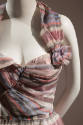 asymmetrical, strapless dress with pink metallic, light purple, grey, and white stripes; boned …