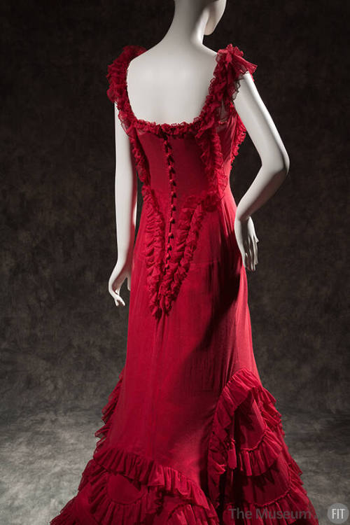 Back view of red sleeveless floor length dress with ruffle trim and button back 