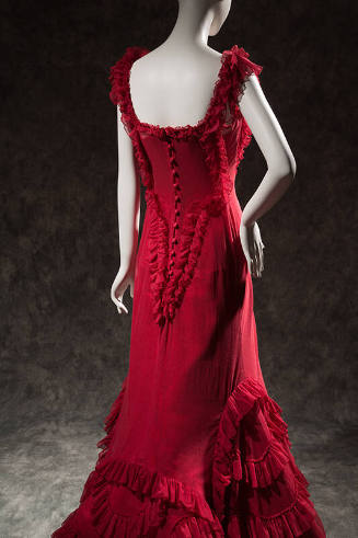 Back view of red sleeveless floor length dress with ruffle trim and button back 
