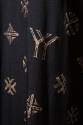 Detail of black fabric with beige YY monogram and cross designs