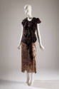 Evening ensemble of dark brown sleeveless top with asymmetrical front ruffle and calf length br…