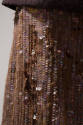 Detail view of evening ensemble skirt showing brown ground, iridescent sequins and burn holes 