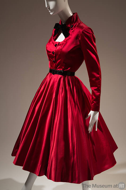 Red long sleeve cocktail dress with pleated calf length skirt and narrow, black belt at waist