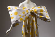 Close up of large, detachable white bow with yellow swirling circles