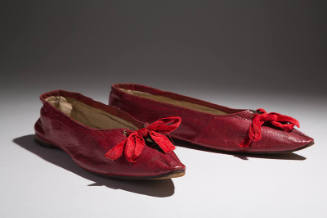 Pair of red leather flat shoes with pointed toe and red ribbon bow tie on vamp 