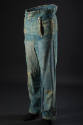 Man’s blue denim trousers with button closure drop front, buttons along waistline and patches a…