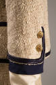 Detail of navy trim and two gold buttons on jacket sleeve 