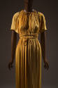 Deep gold evening dress and bolero; sleeveless dress gathered at the neck with tie