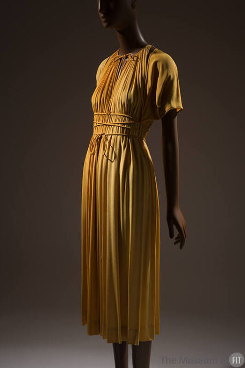 Deep gold evening dress and bolero; sleeveless dress gathered at the neck with tie