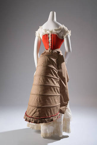 Back view of red laced corset over white lace top; with brown 6-tier bustle and white petticoat