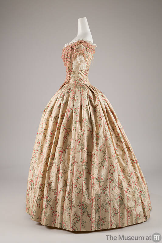 Side view of two-piece floor length dress in pale green with green, grey and red floral print, …