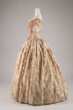 Side view of two-piece floor length dress in pale green with green, grey and red floral print, …