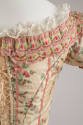 Detail view of pale green two-piece dress laced up back of bodice with two rows of floral bandi…