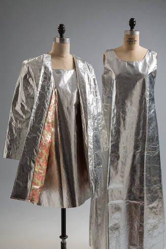 Three silver laminated paper pieces: 3/4 length coat over sleeveless mini dress and sleeveless …