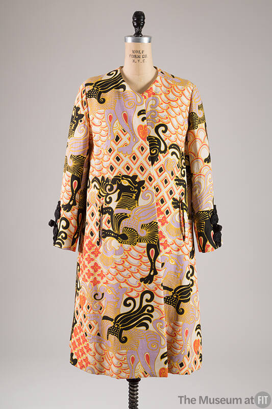 White linen coat printed with winged animal design in black, gold, mauve pink interspersed with…