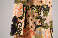 Detail of sleeve of white linen coat printed with winged animal design