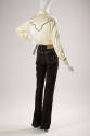 Back view of black four pocket jeans styled with white long-sleeved button down