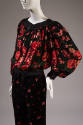 3/4 of black floral print top and matching pants set showing black satin neckline, waistband an…
