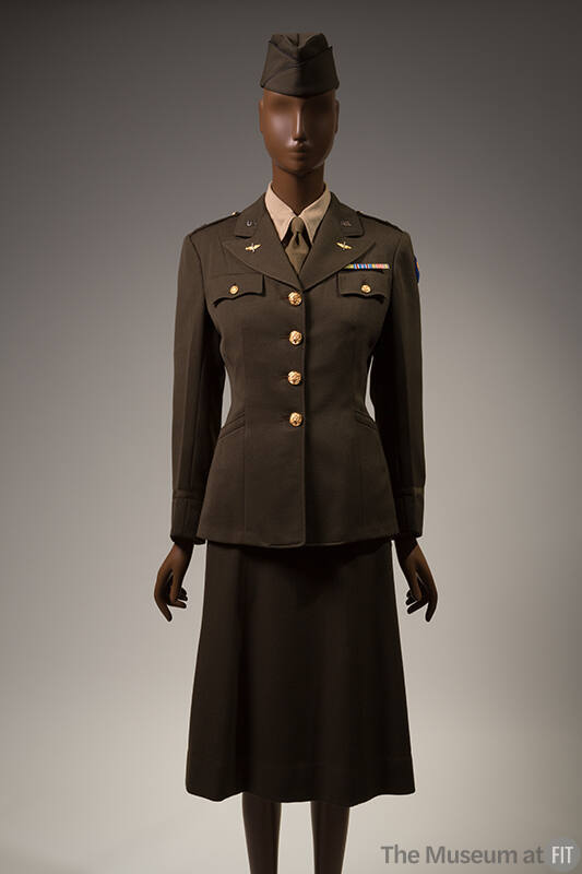 Women's Army green uniform suit, fitted jacket with large gold buttons, wings and U.S. pins on …
