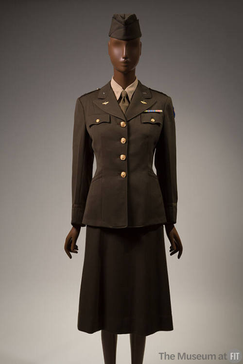 Women's Army green uniform suit, fitted jacket with large gold buttons, wings and U.S. pins on …