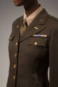 3/4 view of Army uniform jacket showing gold buttons, patch pockets, pins on lapels and multico…
