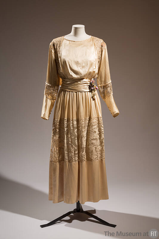 Cream above the ankle length afternoon dress with long sleeves, insets of lace at shoulders, sl…