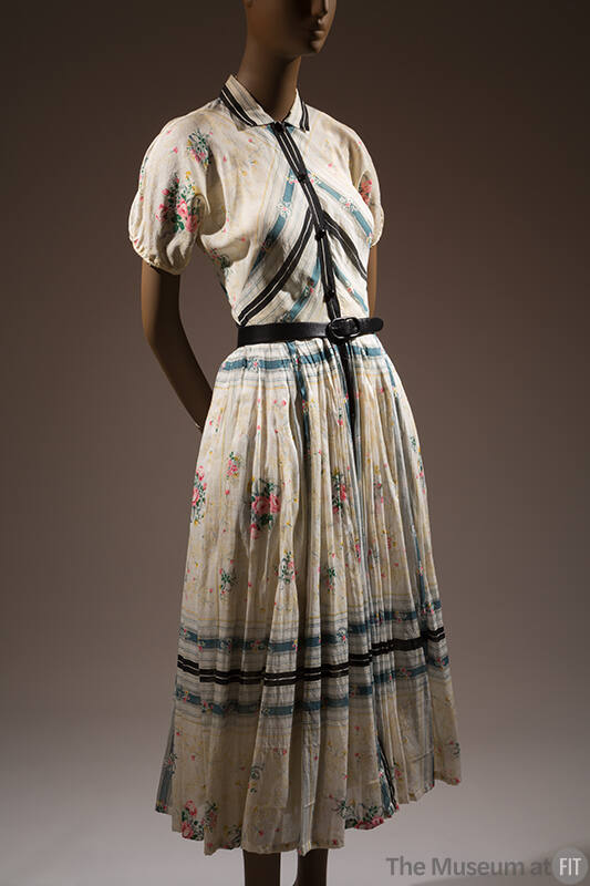 White short sleeve dress with floral print, blue and black trim and pleated skirt