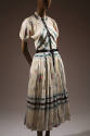White short sleeve dress with floral print, blue and black trim and pleated skirt