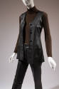Detail of black leather button front vest, brown turtleneck long sleeve top and black leather p…