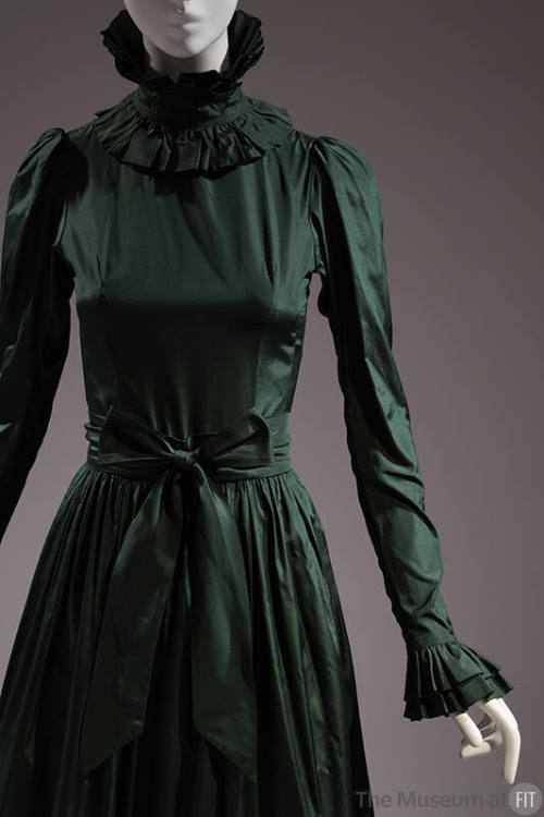 Detail of green taffeta gown with high ruffle neck, long sleeve with ruffle cuff, gathered skir…