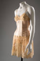 Pink satin boned corset over lace slip, thin shoulder straps, garters under skirt