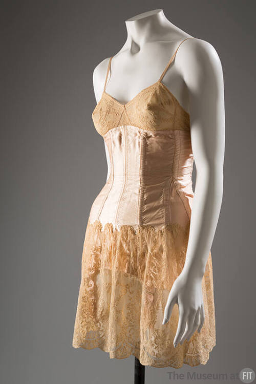 Pink satin boned corset over lace slip, thin shoulder straps, garters under skirt