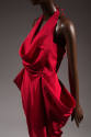 Detail of sleeveless red dress with cowl front halter bib over strapless bodice; wrap skirt wit…