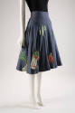 Blue denim flared skirt scattered with printed and stuffed vegetable appliqués