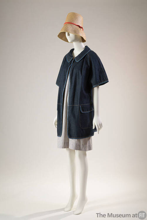 Denim short sleeve hip length jacket with flap pockets over a blue and white striped to-the-kne…