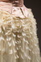 Back detail of pink bodice and off-white net and feather skirt 