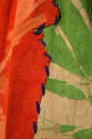 Detail of orange, green and beige fabric with purple stitching
